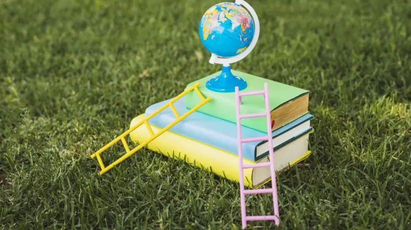 mini-globo-encima-pila-libros-texto