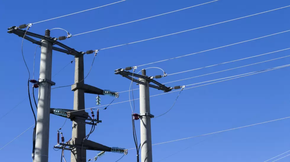 shot-electric-posts-lines-against-blue-background