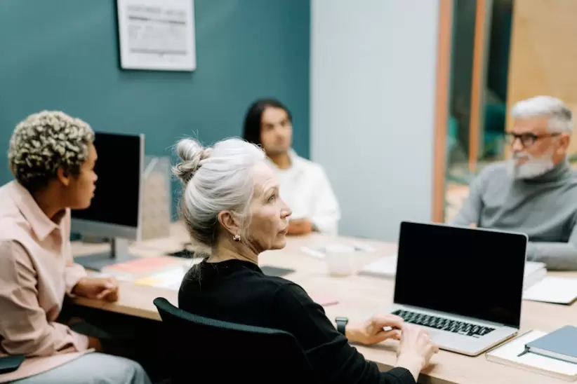 Mujer En Suter Negro Sentada En Una Silla Frente A Macbook Pro