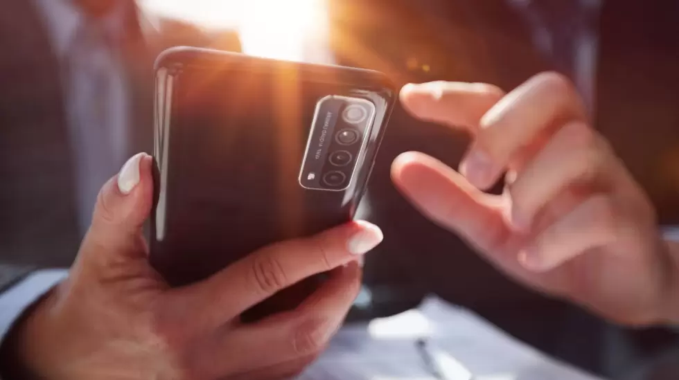 manager-uses-smartphone-while-sitting-table-with-colleague