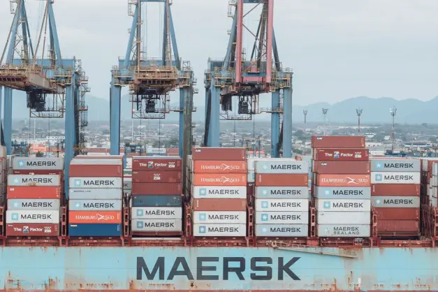 Gran buque de carga cargado con contenedores de transporte en un puerto industrial muy activo. (Foto: Pexels)