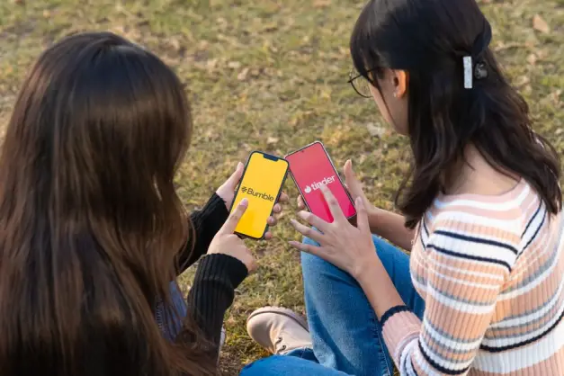 Dos mujeres usan las aplicaciones de citas Bumble y Tinder en teléfonos inteligentes en un parque. (Foto: Pexels)