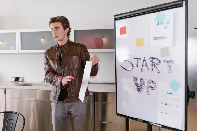 Un joven emprendedor realiza una presentación sobre estrategias de startup en interiores con un rotafolio. (Foto: Pexels)