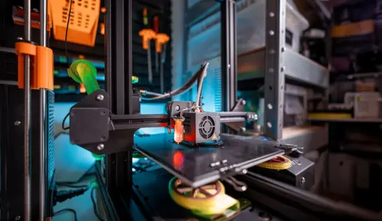 Vista detallada de una impresora 3D trabajando activamente en un entorno de taller, mostrando tecnología moderna. (Foto: Pexels)