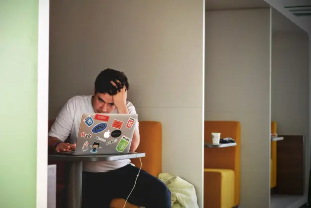Hombre mostrando estrés y frustración mientras trabaja de forma remota en un portátil en interiores. (Foto: Pexels)