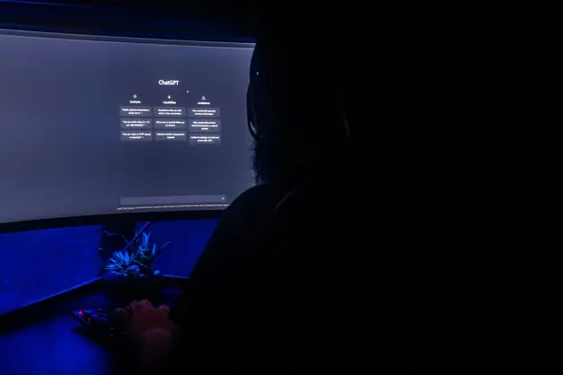 Silueta de una persona utilizando ChatGPT en la pantalla de un ordenador en una habitación oscura, destacando la interacción digital. (Foto: Pexels)