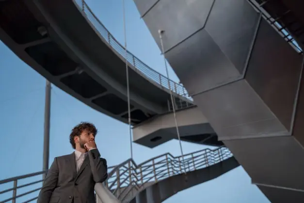 Hombre joven en un traje de pie junto a una maravilla arquitectónica, símbolo del diseño urbano moderno. (Foto: Pexels)