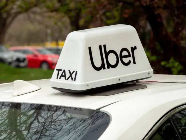 Primer plano de un letrero blanco de Uber en el techo de un coche en Breslavia, Polonia. (Foto: Pexels)