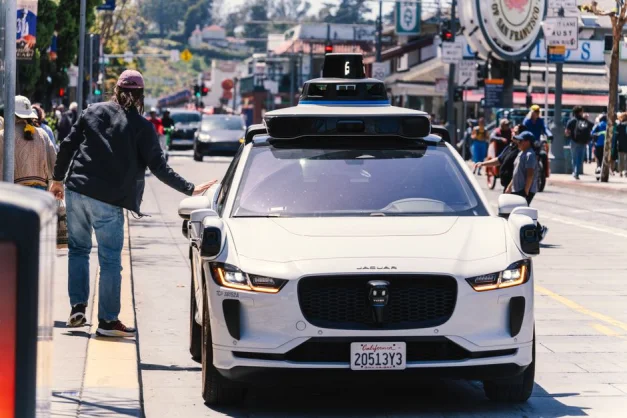 Un automóvil autónomo circula por una bulliciosa calle de San Francisco, capturando la movilidad urbana en acción.