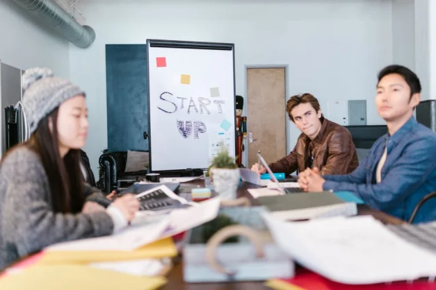 Un grupo de jóvenes profesionales generando ideas en un entorno de oficina de startup.