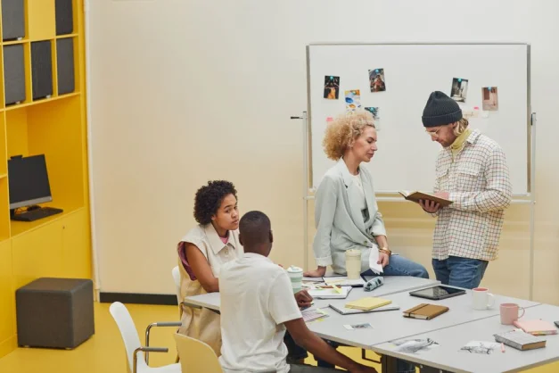 Un grupo diverso de compañeros de trabajo colaborando en un proyecto en un entorno de oficina moderna.