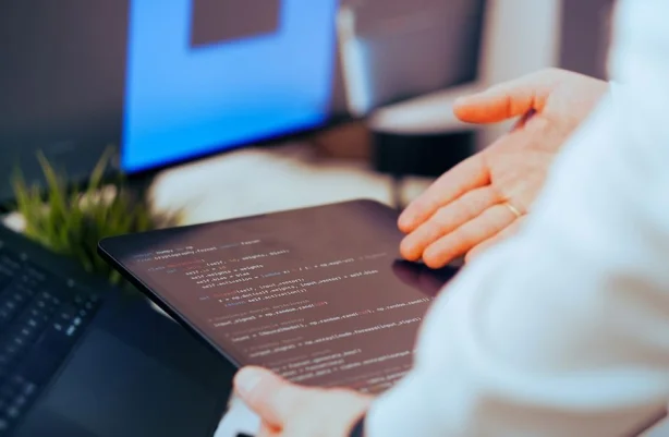 Un desarrollador de software analiza código en una tableta en un espacio de trabajo de oficina moderno.