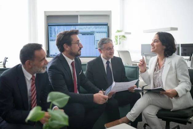 Profesionales de negocios diversos participando en una animada reunión en la oficina, fomentando la colaboración y el trabajo en equipo.