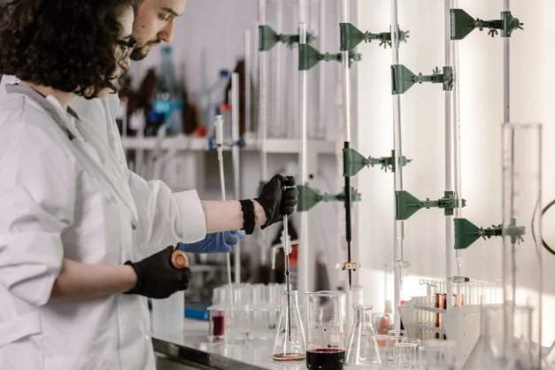 Científicos con batas trabajan con tubos de ensayo en un laboratorio moderno.