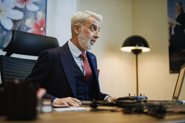 Hombre de negocios mayor en su escritorio de oficina, concentrado en el trabajo, con una configuración moderna y elegante.